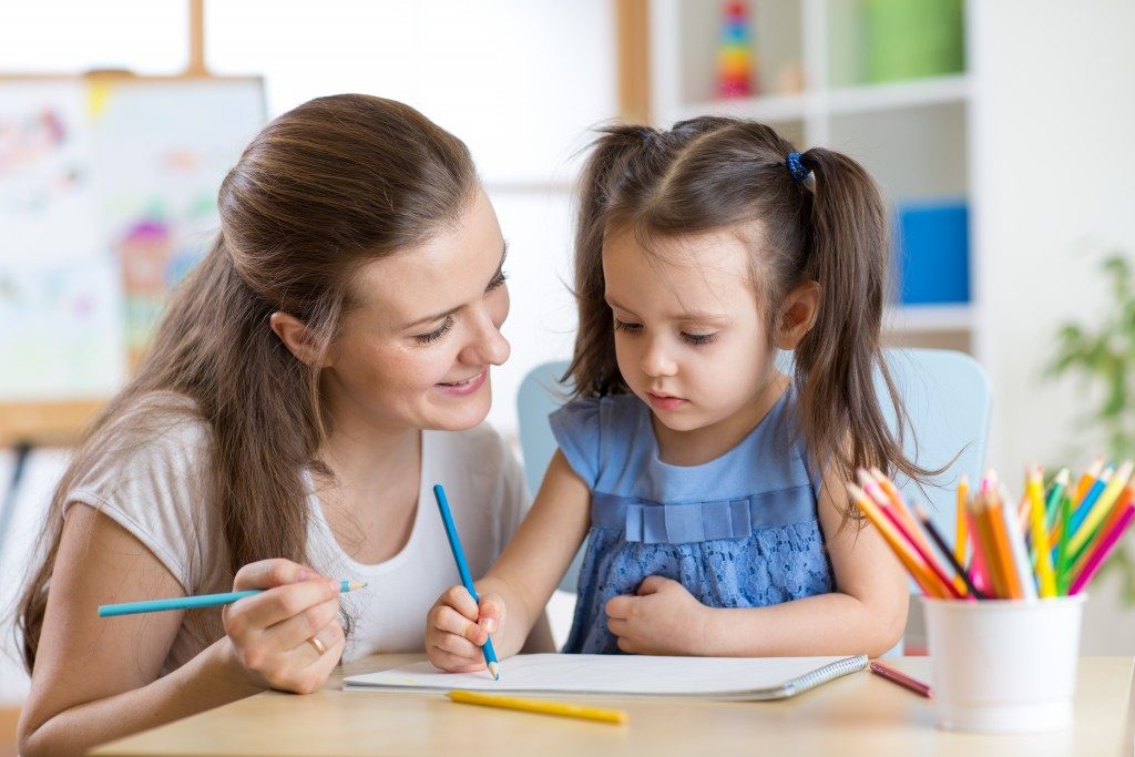 a mother joining her daughter in learning how to write