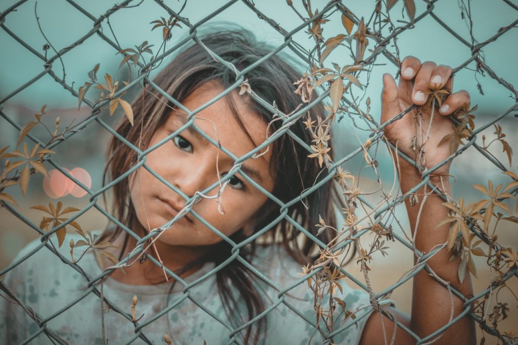 young child holding on to steel fence